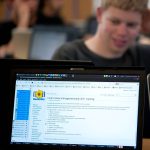 programmer reviewing code on a monitor