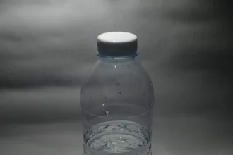A single plastic bottle of water photographed against a plain background
