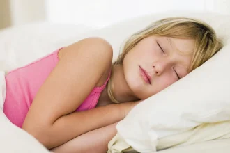 A young woman sleeping on her side in soft daylight