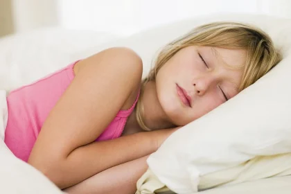 A young woman sleeping on her side in soft daylight