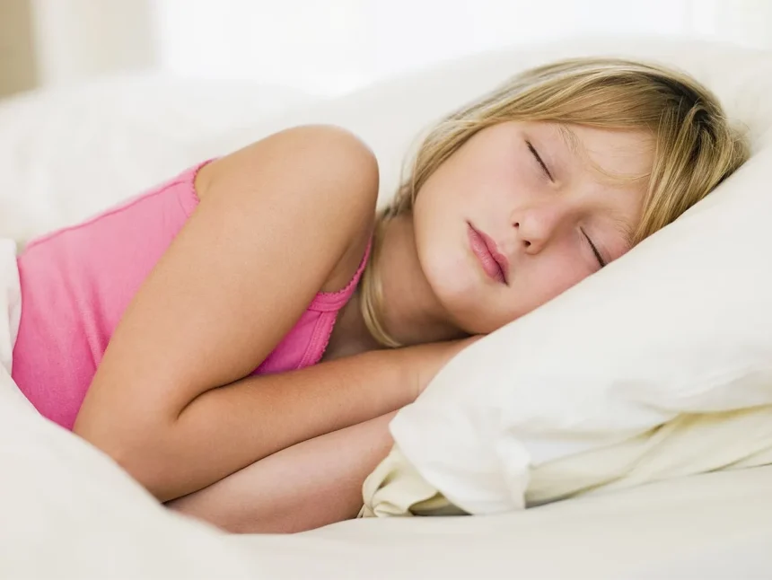 A young woman sleeping on her side in soft daylight