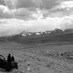 A traveller with a backpack walking a mountain road