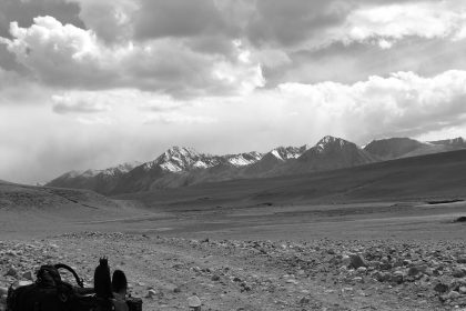 A traveller with a backpack walking a mountain road